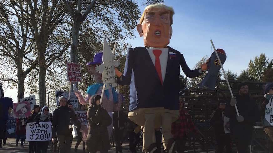 Protesters dance with giant puppets to the Art Museum steps in support of