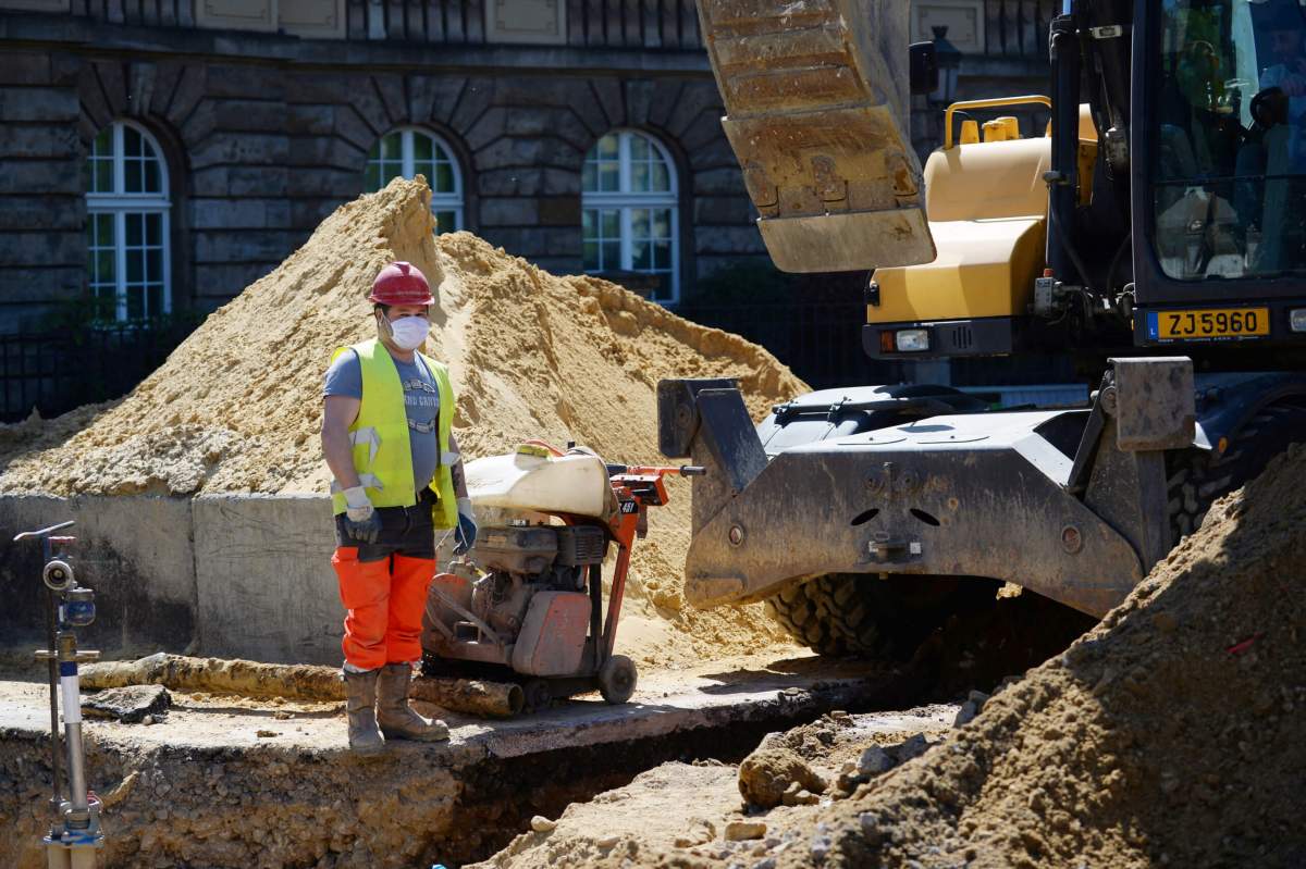 Workers wearing face masks work at a construction site in Luxembourg