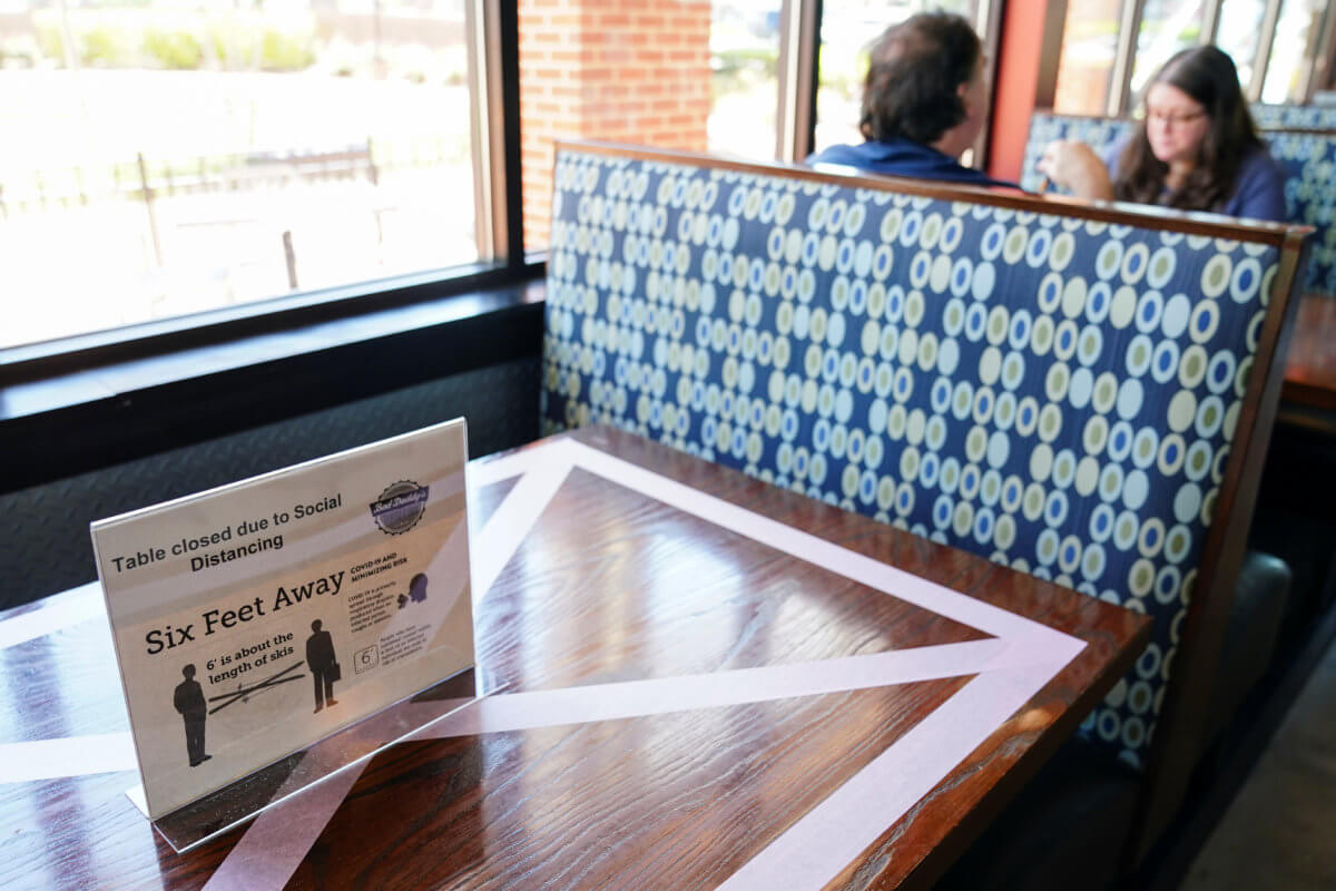 Customers eat lunch next to a table closed for social distancing at Bad Daddy’s Burger Bar on the day restaurants and theaters were allowed to reopen to the public as part of the phased reopening of businesses from the coronavirus disease rules in Smyrn