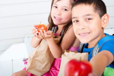 Siblings eating school lunch