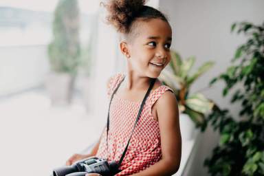 Adorable child with binoculars aroud her neck