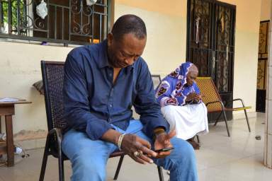 Ibrahima Keita checks his mobile phone at his family house in Bamako