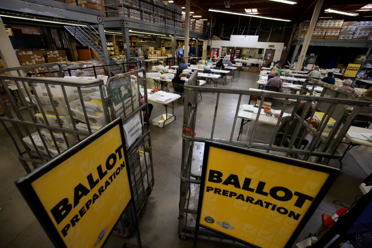 FILE PHOTO: Some of the hundreds of thousands of early mail-in ballots are processed for scanning by election workers at the Orange County Registrar of Voters in Santa Ana, California,