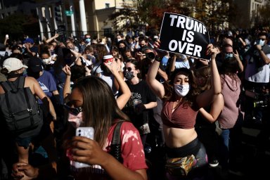 People react as media announce that Democratic U.S. presidential nominee Joe Biden has won the 2020 U.S. presidential election in Washington