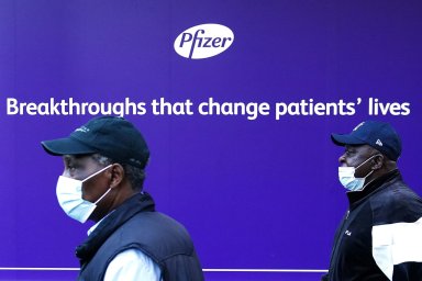 A person walks past the Pfizer Headquarters building