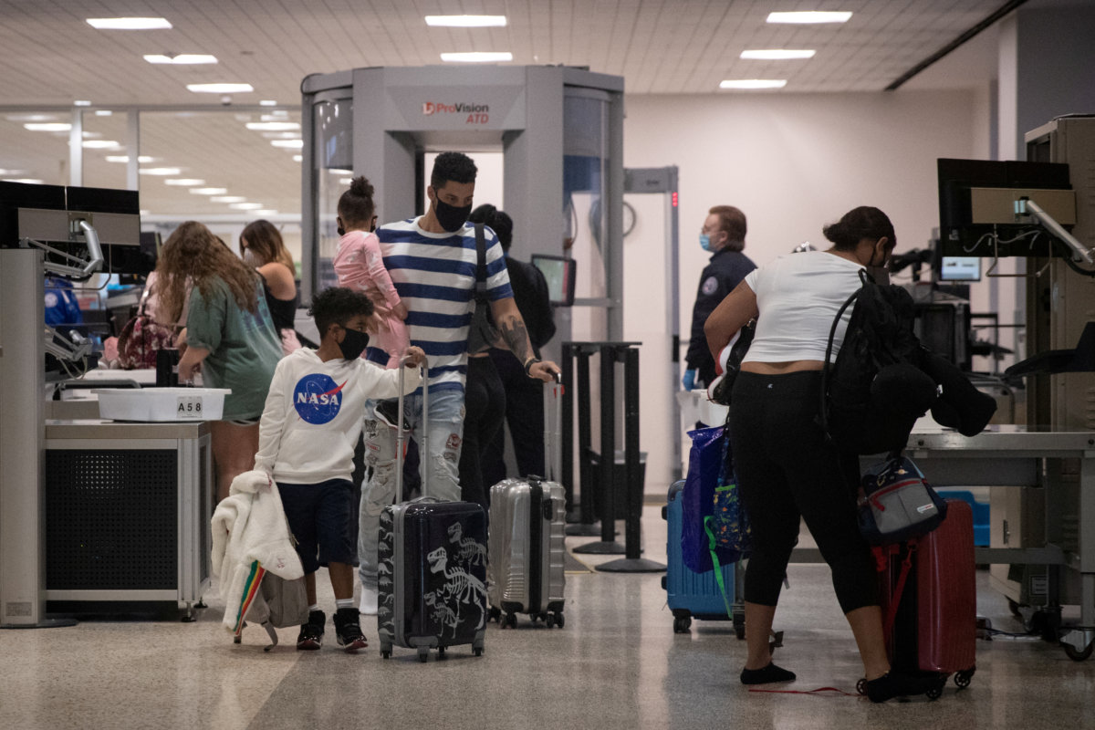 FILE PHOTO: A family wears face masks after passing security at IAH George Bush Intercontinental Airport in Houston