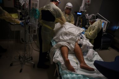 FILE PHOTO: Healthcare personnel work with a patient inside a room for people with coronavirus disease (COVID-19) at a hospital in Hutchinson