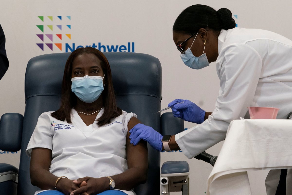 Sandra Lindsay,  a nurse at Long Island Jewish Medical Center, is inoculated with the coronavirus disease (COVID-19) vaccine by Dr. Michelle Chester from Northwell Health at Long Island Jewish Medical Center in New Hyde Park, New York