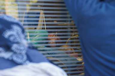 Nurse Carolina Garcia, 36, is seen through the window taking care of her father, Jose Garcia, 67, who is currently intubated and sedated due to COVID-19 during a surge of coronavirus disease (COVID-19) cases at Memorial Medical Center in Las Cruces