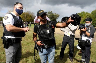 Proud Boys Chairman Enrique Tarrio talks with a law enforcement officer in Portland