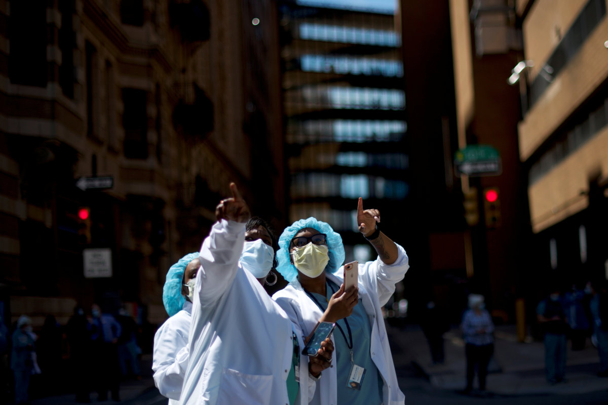 Healthcare workers react as they watch a flyover in Philadelphia