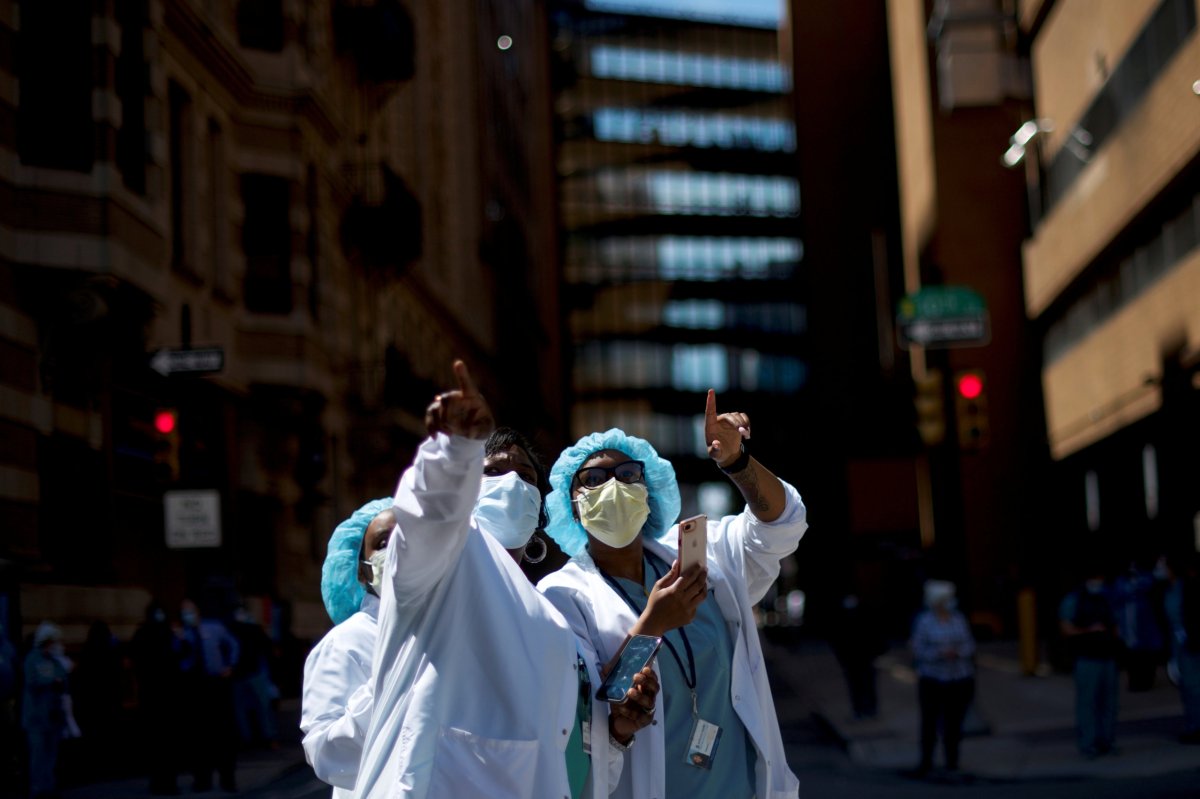 Healthcare workers react as they watch a flyover in Philadelphia