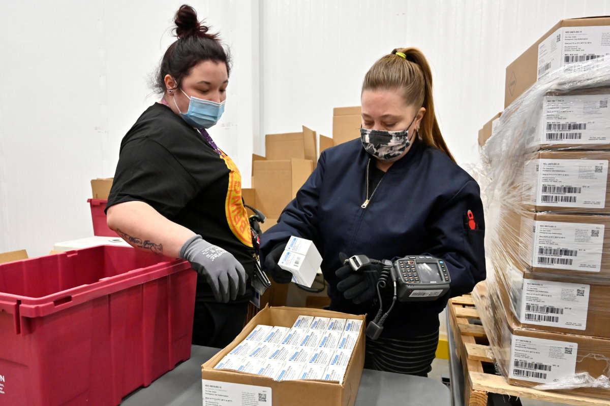 An employee with the McKesson Corporation scans a box of the Johnson & Johnson COVID-19 vaccine, in Shepherdsville