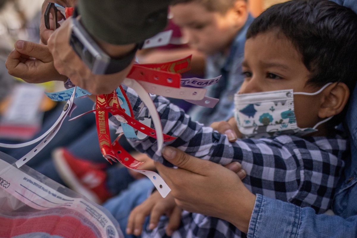 Border Patrol Agent removes wristband worn by asylum seeking migrant boy in Penitas, Texas