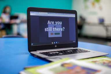 FILE PHOTO: Young students continue their online distant schooling from a monitored multipurpose room at the YMCA in Los Angeles