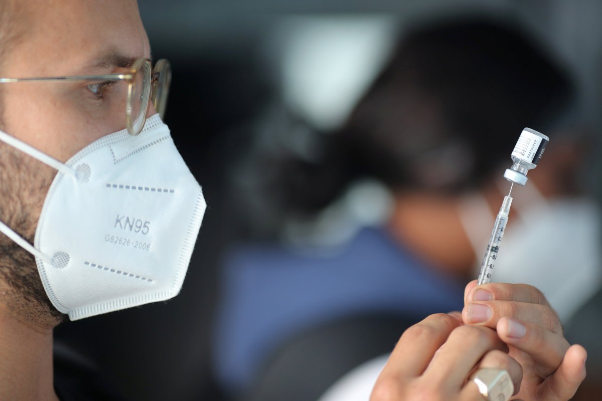 EMT Lenny Fernandez prepares a Pfizer coronavirus disease (COVID-19) vaccination at a mobile vaccination drive for essential food processing workers at Rose & Shore, Inc., in Vernon, Los Angeles