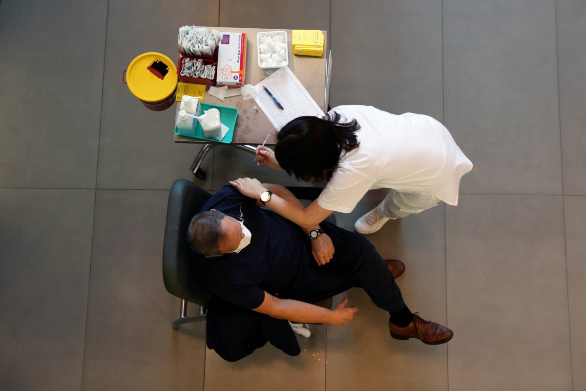 FILE PHOTO: A medical worker vaccinates a man against the coronavirus disease (COVID-19) as Israel kicks off a coronavirus vaccination drive, at Tel Aviv Sourasky Medical Center (Ichilov Hospital) in Tel Aviv