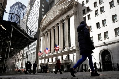 FILE PHOTO: People are seen on Wall St. outside the NYSE in New York