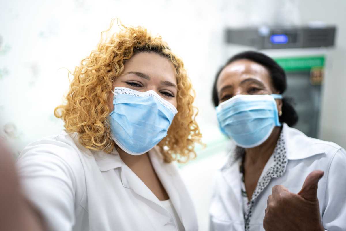 Happy healthcare coworkers taking a selfie at hospital