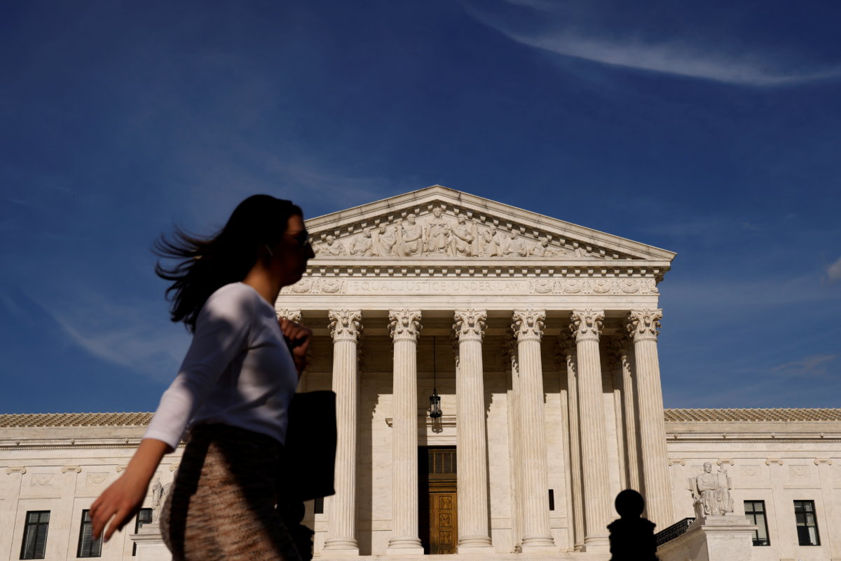 FILE PHOTO: A woman walks past the U.S. Supreme Court building in Washington