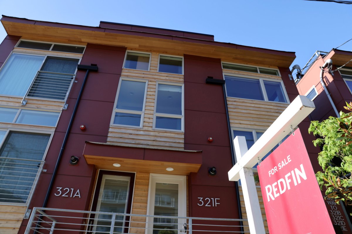 FILE PHOTO: A “For Sale” sign is posted outside a residential home in Seattle