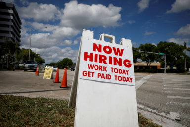 FILE PHOTO: A “Now Hiring” sign advertising jobs at a hand car wash is seen in Miami
