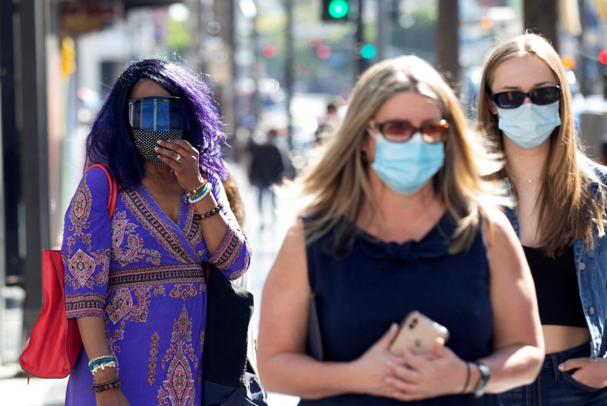 FILE PHOTO: People wearing face protective masks walk on Hollywood Blvd during the outbreak of the coronavirus disease (COVID-19), in Los Angeles