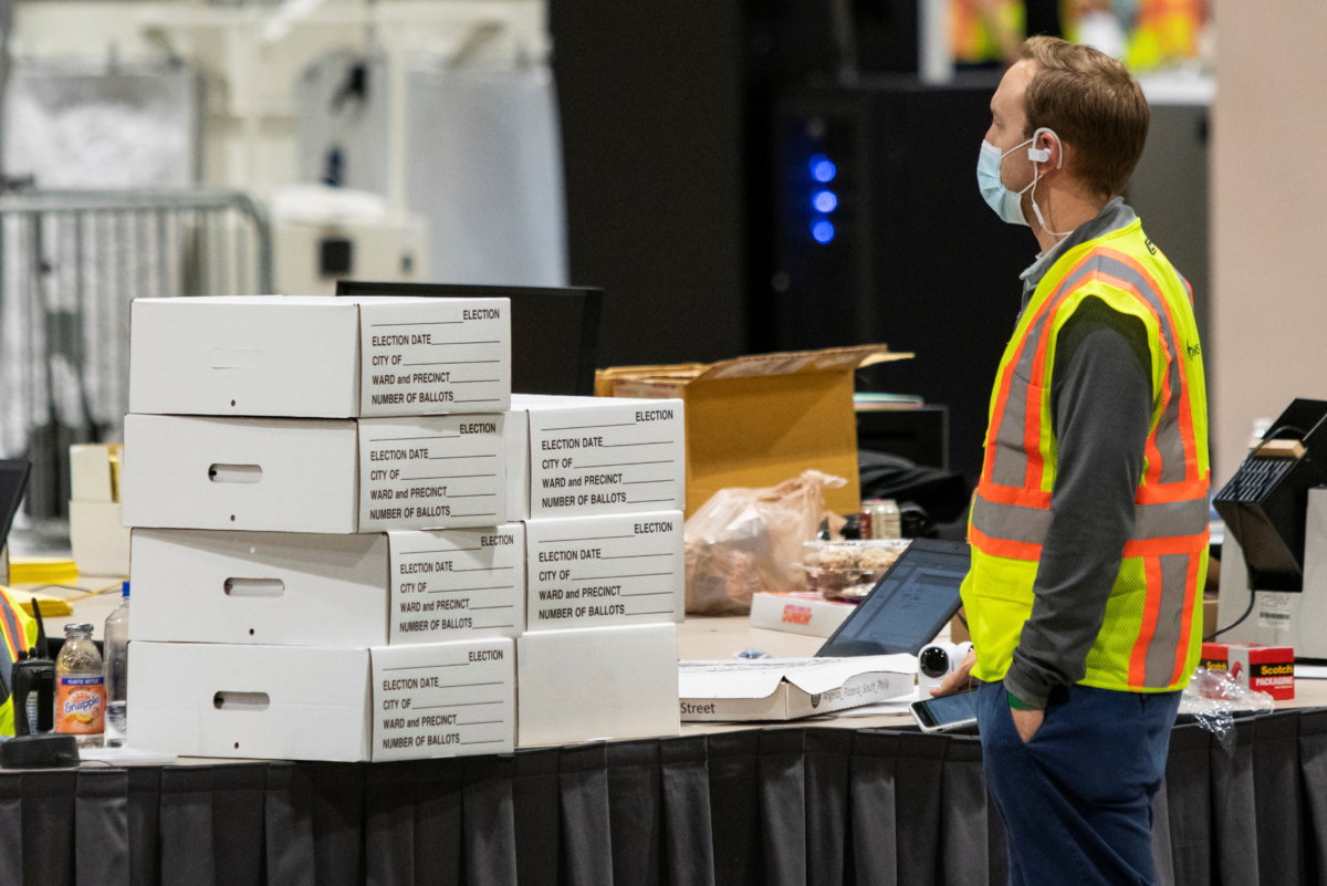An electoral worker stands next to boxes with ballot material following the 2020 U.S. presidential election, in Philadelphia