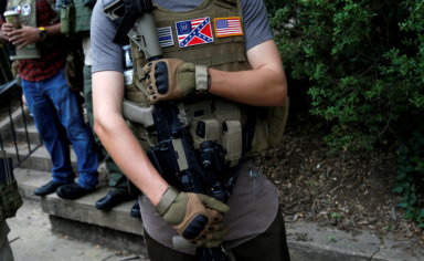FILE PHOTO: A member of a militia stands near a rally in Charlottesville Virginia