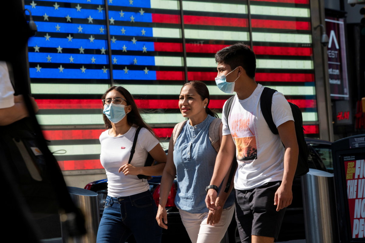 People wear masks around Times Square, as cases of the infectious coronavirus Delta variant continue to rise in New York City, New York