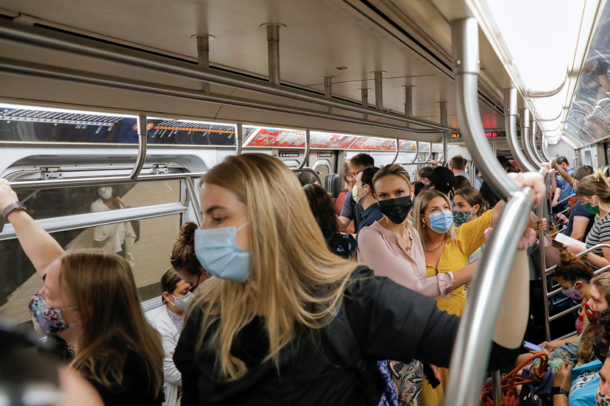 People wear masks while riding on the subway as cases of the infectious coronavirus Delta variant continue to rise in New York City, New York