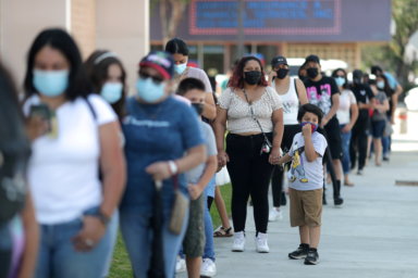 FILE PHOTO: People wait in line for a COVID-19 test at a back-to-school clinic in Los Angeles