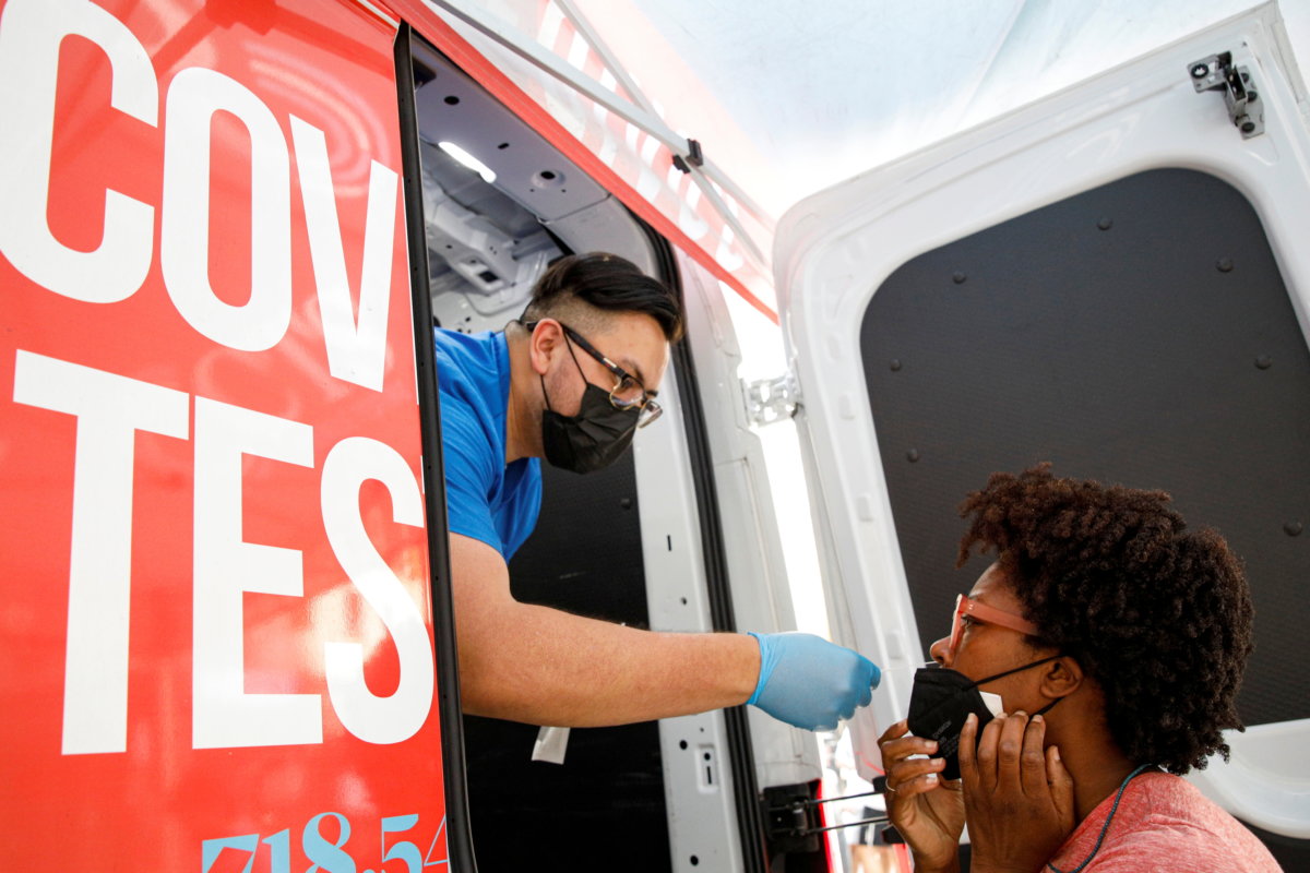 Akyiaa Wilson receives a coronavirus disease (COVID-19) test from technician Adrian Gutierrez at a mobile testing van in New York