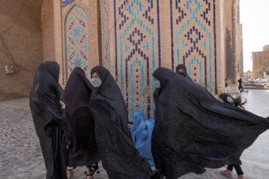 Afghan women walk at a mosque in Herat
