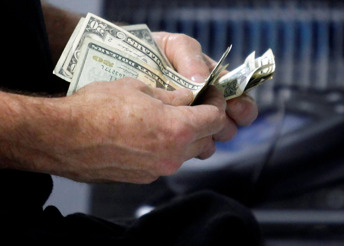 FILE PHOTO: FILE PHOTO: A customer counts his cash at the register while purchasing an item at a Best Buy store in Flushing