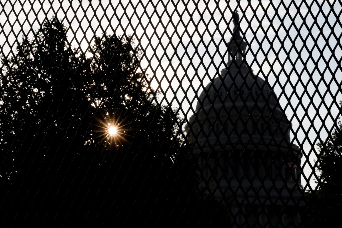 The sun rises behind the U.S. Capitol, surrounded by a security fence ahead of an expected rally Saturday in support of the Jan. 6 defendants in Washington