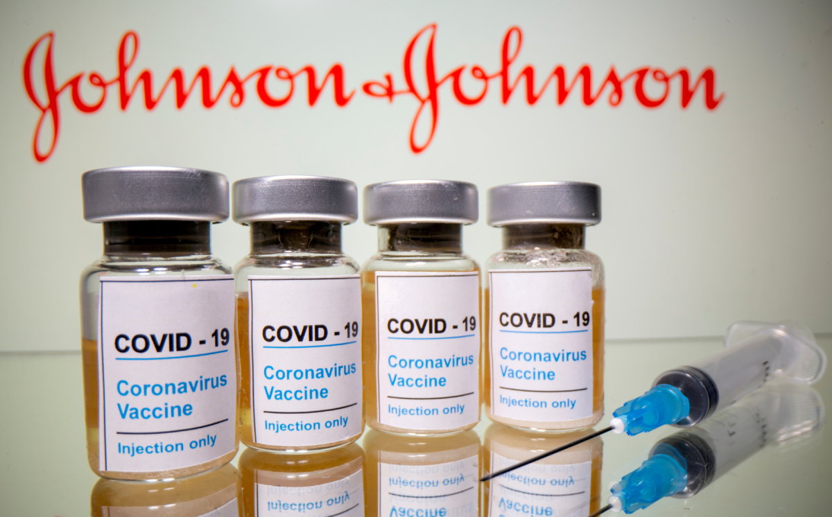 FILE PHOTO: FILE PHOTO: Vials and medical syringe are seen in front of J&J logo in this illustration