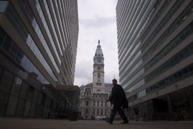 A man walks in front of City Hall in Philadelphia