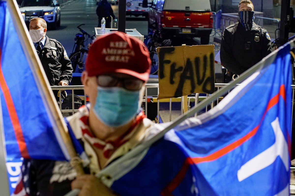 FILE PHOTO: A sign reading “fraud” is pictured near a supporter of U.S. President Donald Trump wearing a Make America Great Again (MAGA) as votes continue to be counted following the 2020 U.S. presidential election, in Philadelphia, Pennsylvania