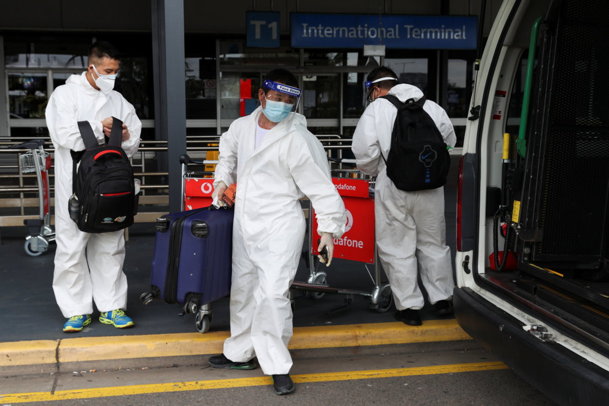 Travellers wear personal protective equipment outside the international terminal at Sydney Airport in Sydney