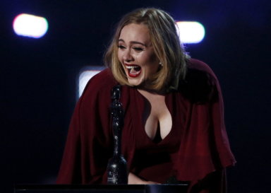 FILE PHOTO: Adele reacts as she accepts the global success award at the BRIT Awards at the O2 arena in London