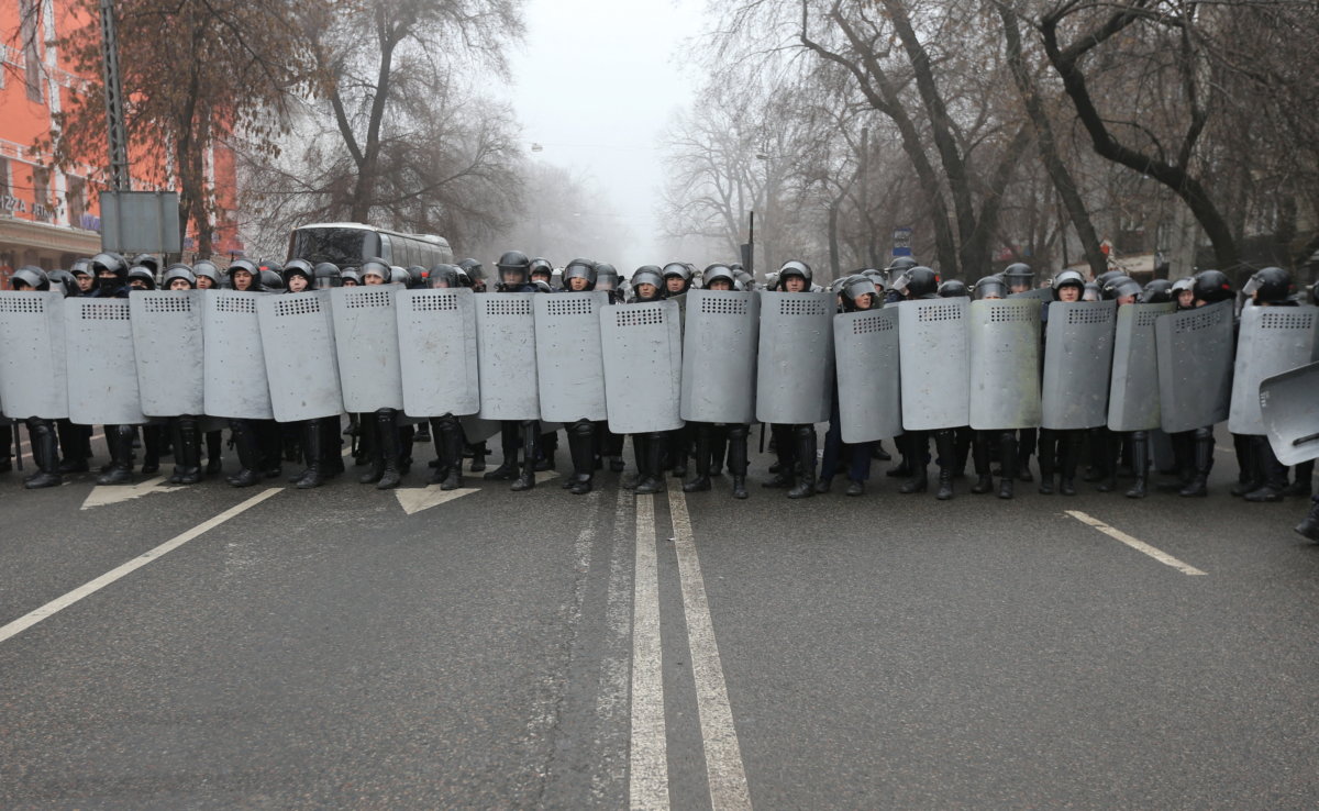 Kazakh law enforcement officers block a street during a protest triggered by fuel price increase in Almaty