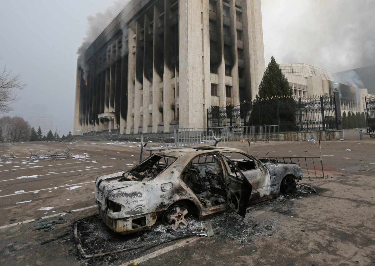 A burned car is seen in front of the mayor’s office building which was torched during protests in Almaty