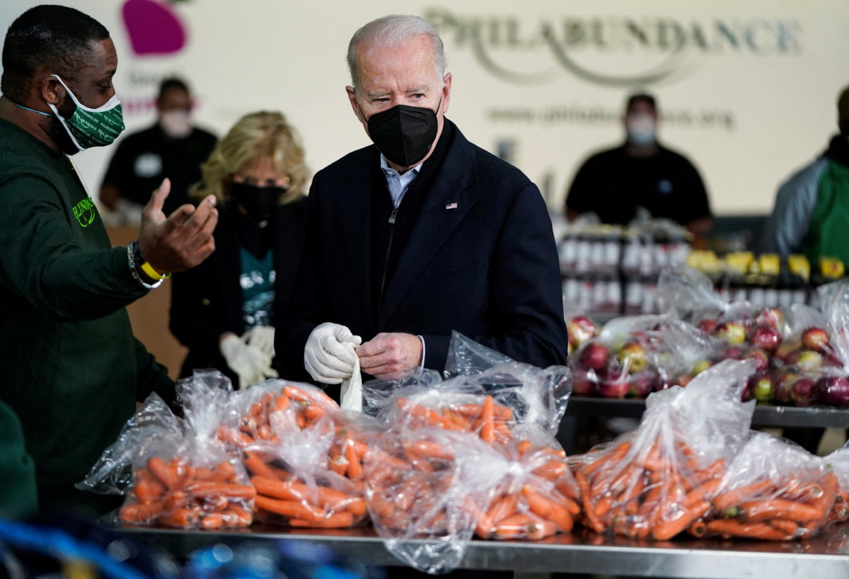 U.S. President Joe Biden fills boxes at a food bank in Philadelphia, Pennsylvania
