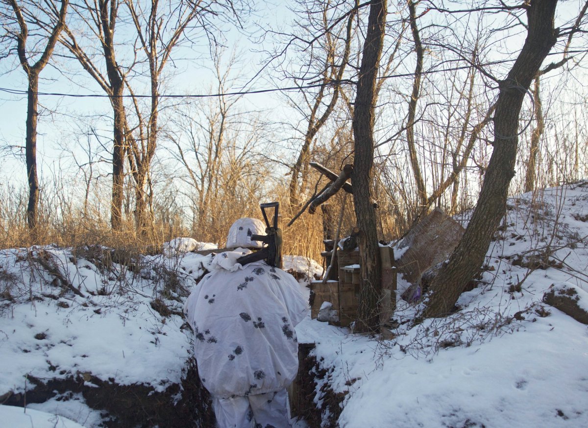 A service member of the Ukrainian armed forces stands guard at combat positions in Donetsk region