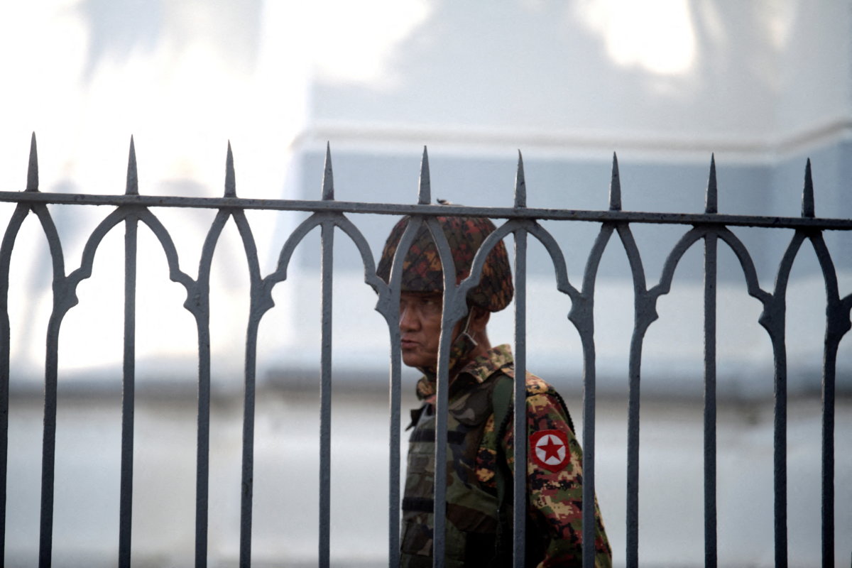 FILE PHOTO: A Myanmar soldier looks on as he stands inside city hall after soldiers occupied the building, in Yangon