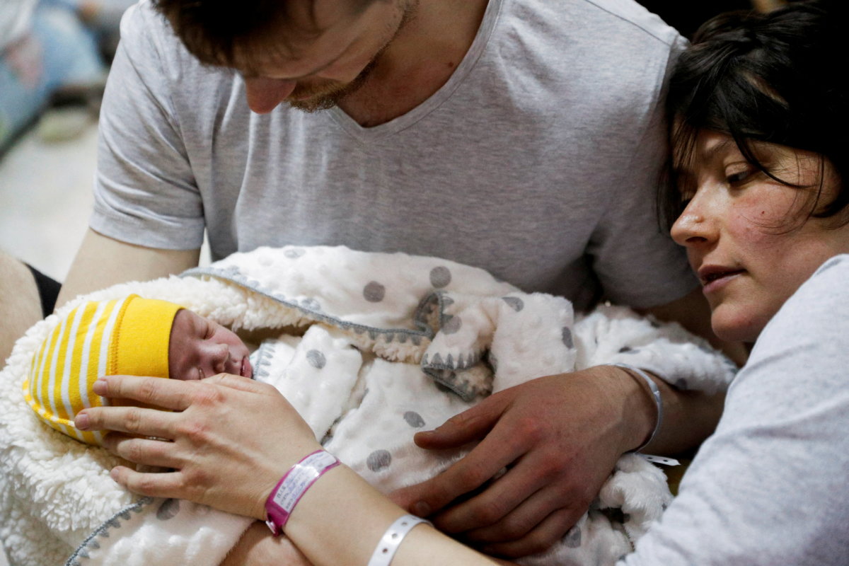 A couple with their newborn baby take shelter in the basement of a perinatal centre as air raid siren sounds are heard amid Russia’s invasion of Ukraine, in Kyiv