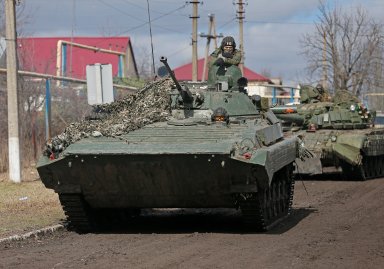 Service members of pro-Russian troops in uniforms without insignia drive an armoured vehicle in the Donetsk region