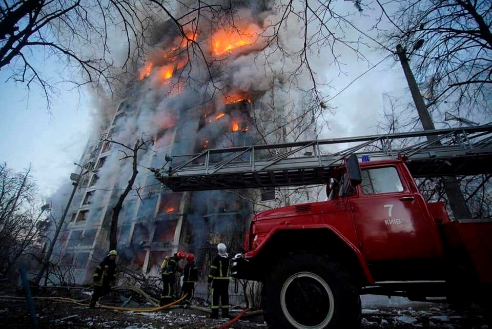 Rescuers work next to a residential building damaged by shelling in Kyiv