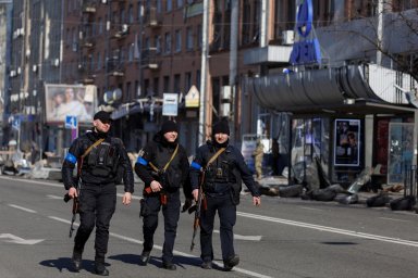 Armed police officers walk past the Artem factory in Kyiv after it was hit by shelling as Russia’s attack on Ukraine continues